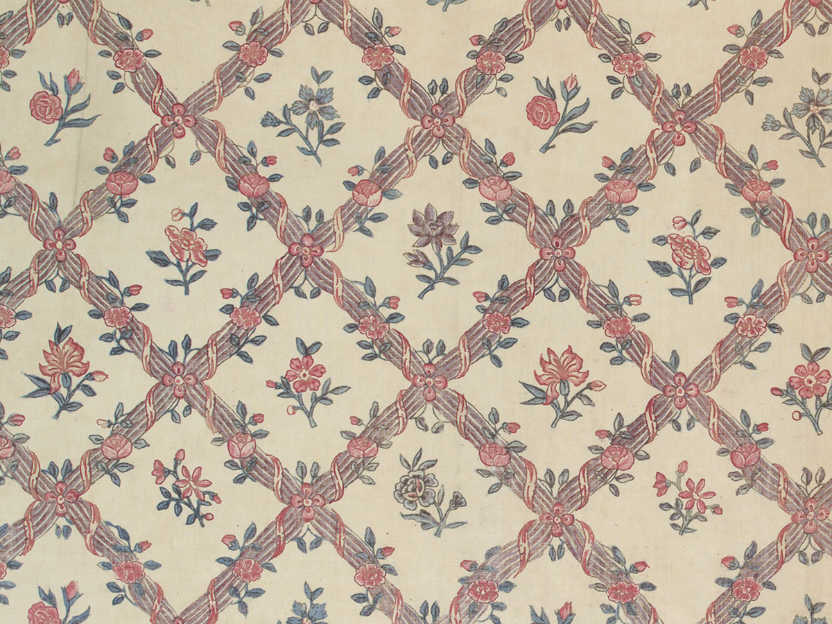 A Chintz textile detail bearing a latticed vegetal pattern, with small floral motifs inside each grid.