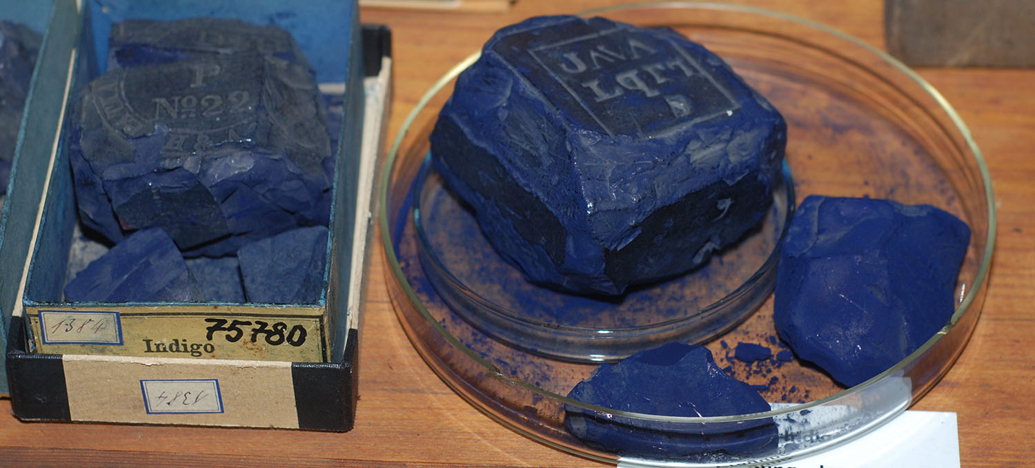 Chipped block of indigo dye in a petri dish, next to a box labelled Indigo 75780.