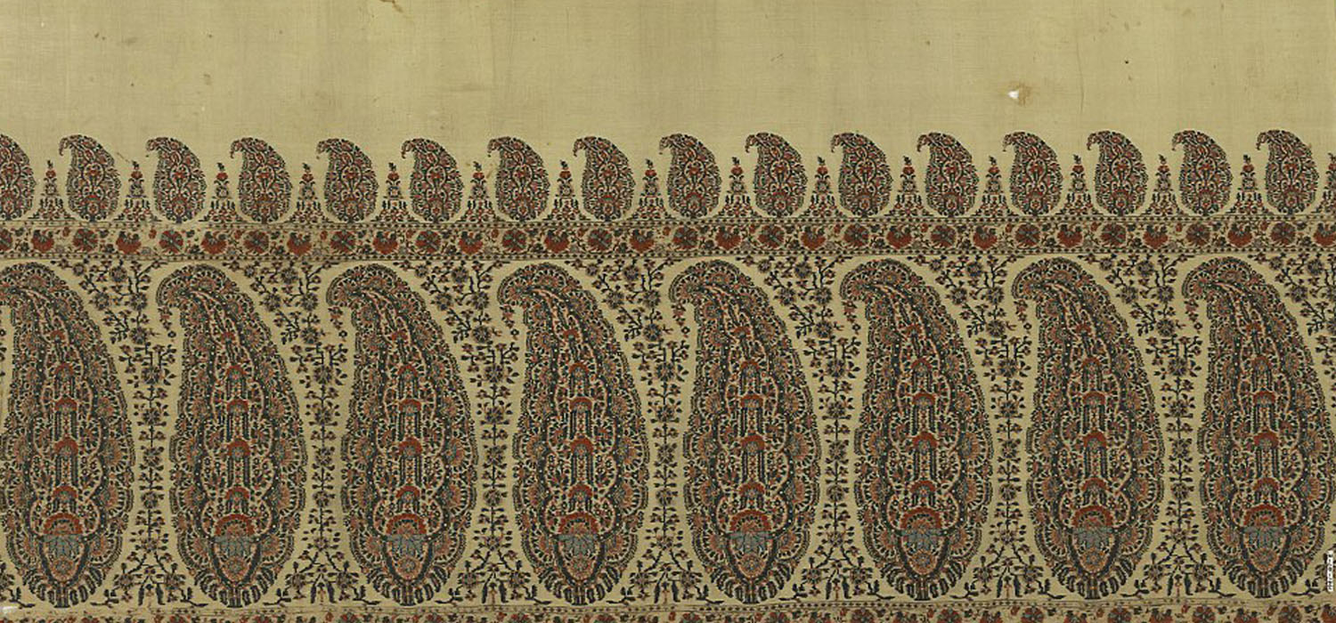 A detail of a shawl border with rows of large and small paisley motifs.