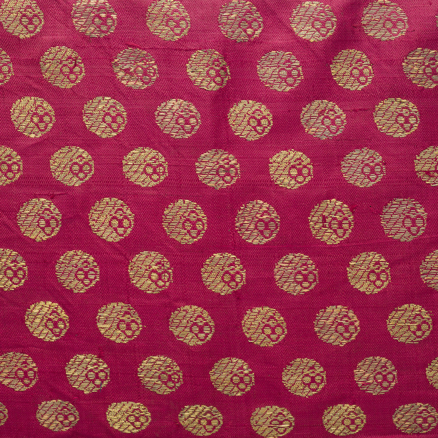 Multiple coin-shaped ashrafi motifs made of gold brocade on a piece of textile