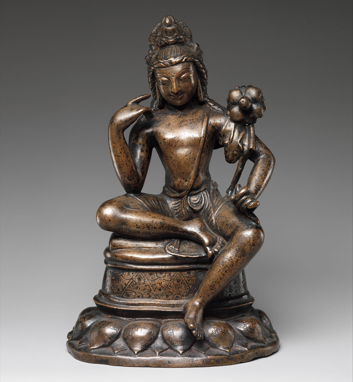 A bronze statue depicting Avalokiteshvara Padmapani, seated with the left leg hanging down.