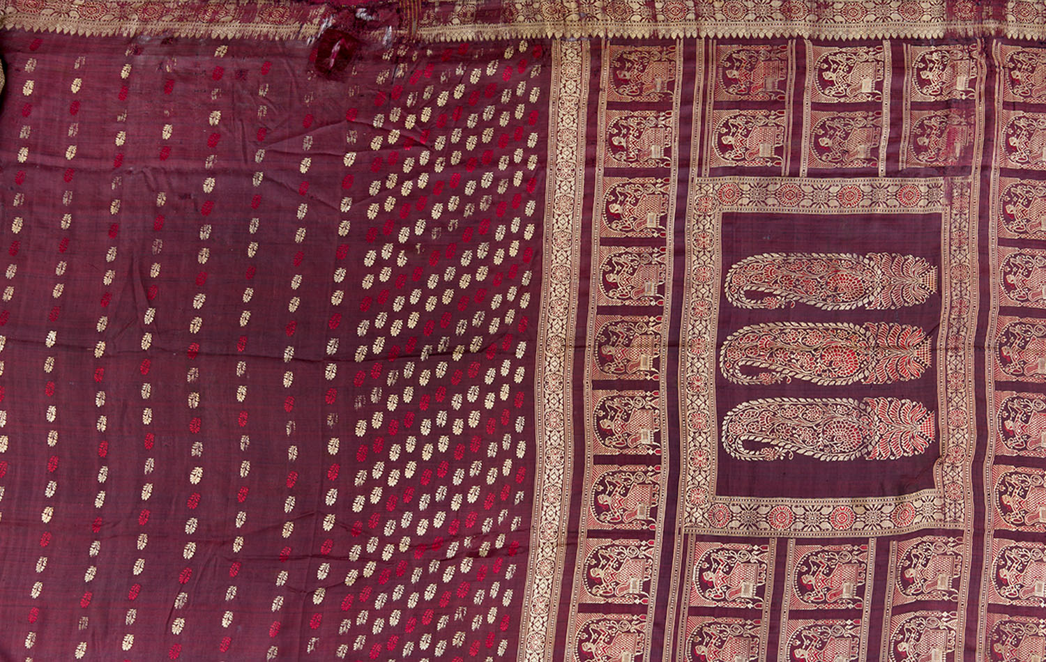 A Baluchari saree with the pallu bearing paisley motifs within a rectangular border composed of a repeating figure of a seated man.