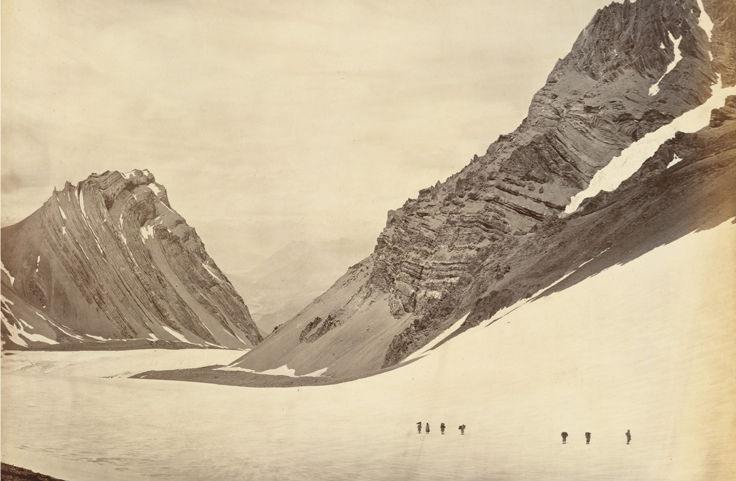 A sepia-toned photograph of the Manirung Pass in the Himalayas, with mountains covered in snow.