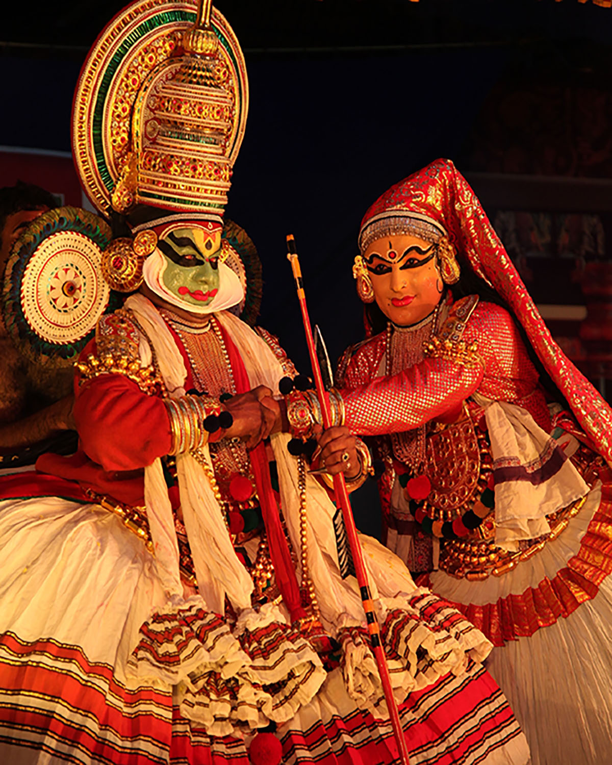 A pair of Kathakali dancers wearing the costume of a male and a female character respectively.