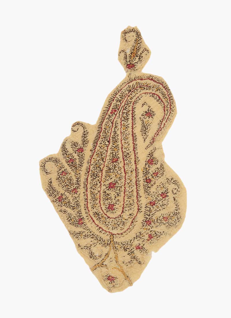 A fragment of a Kashmiri shawl depicting a paisley motif filled with smaller floral details.
