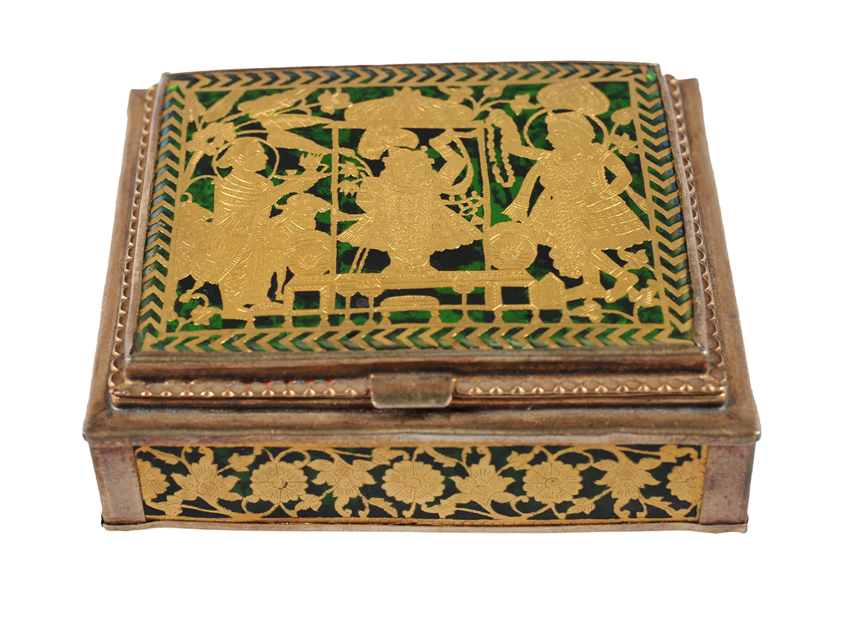Photograph of a silver box with thewa on green glass showing Shrinathji and two devotees on top and floral pattern on front