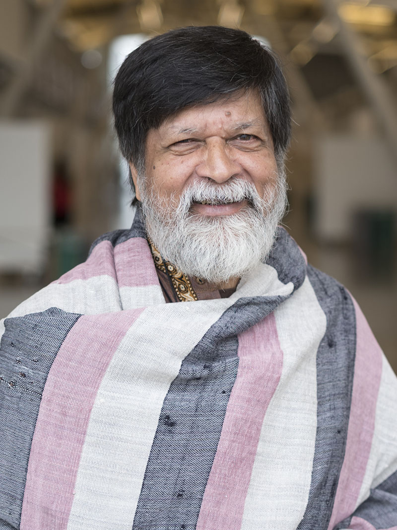 Portrait photograph of Shahidul Alam in a striped shawl